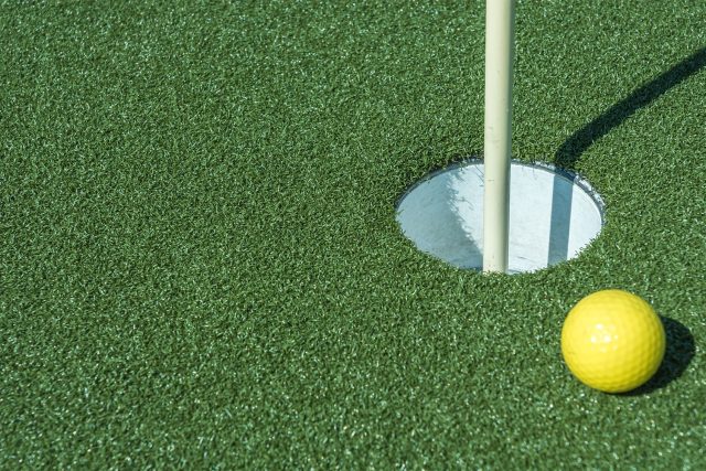 close up of golf putting green made with fake grass